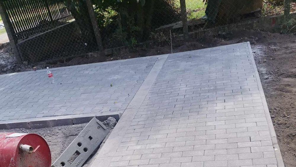 Ipari közmű + térkő – lineáris vízelvezetéses udvar oszlopokkal